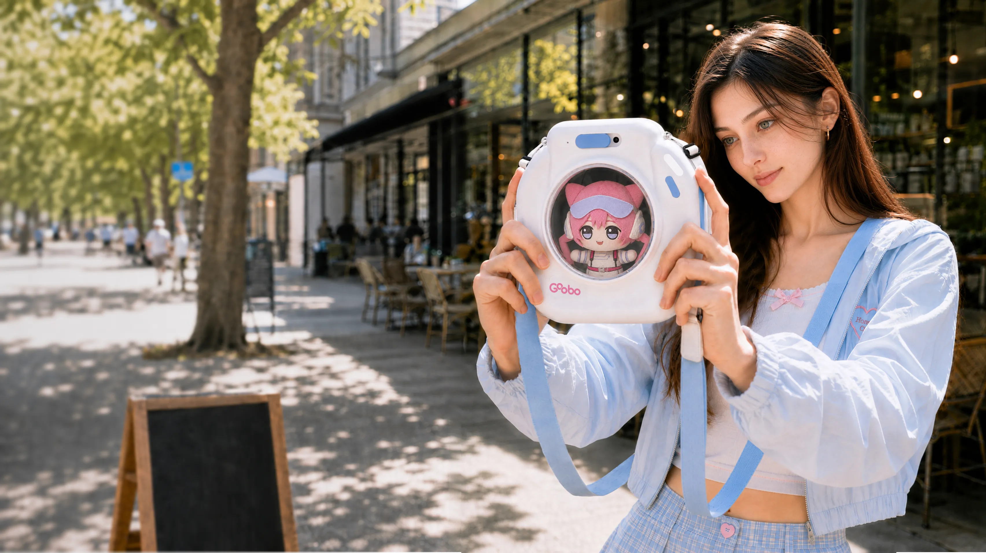 A smiling woman holding the GOOBO smart ita bag with a plush peeking out of its clear window on a sunny waterfront promenade